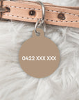 Back of brown dog tag with pet owners phone number